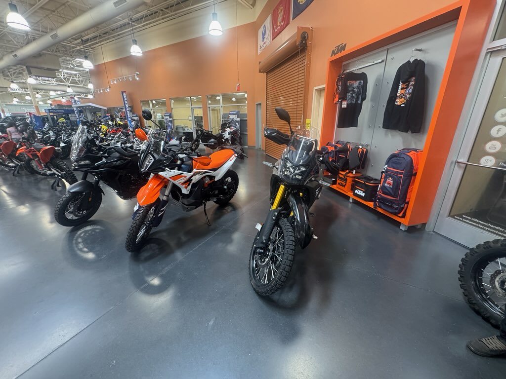 A Yamaha Ténéré 700 and a KTM 890 Adventure R parked on an adventure-bike dealer floor